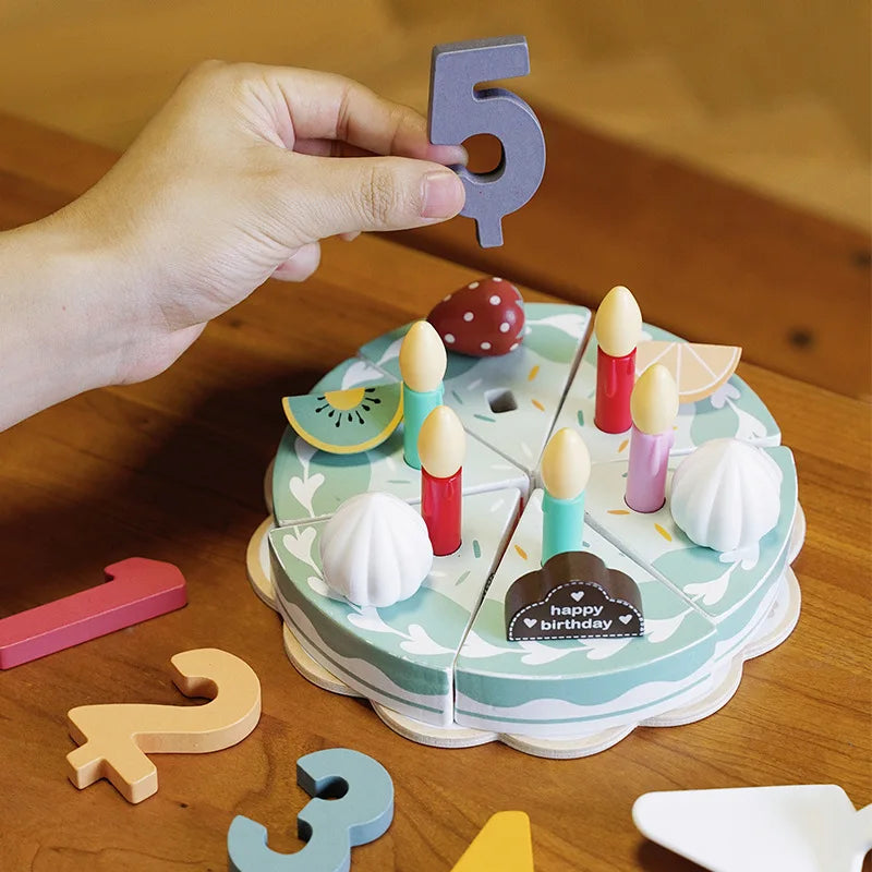 Hand holding a purple number five decoration above the wooden birthday cake