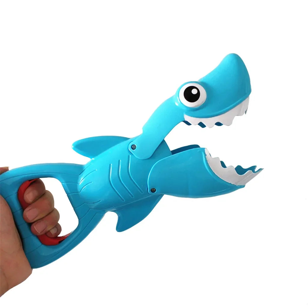 Blue shark bath toy with open jaws and a hand gripping its loop handle