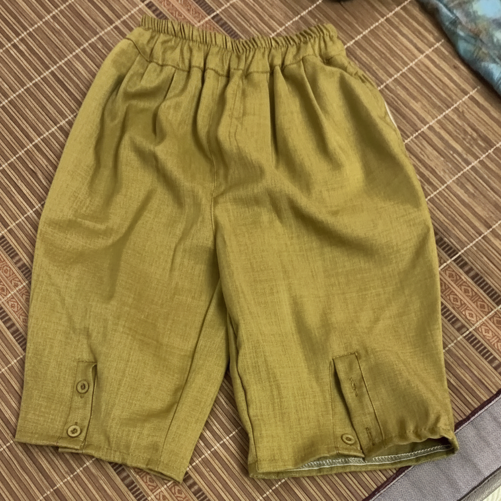 Olive-green shorts with an elastic waistband and small buttons at the leg openings