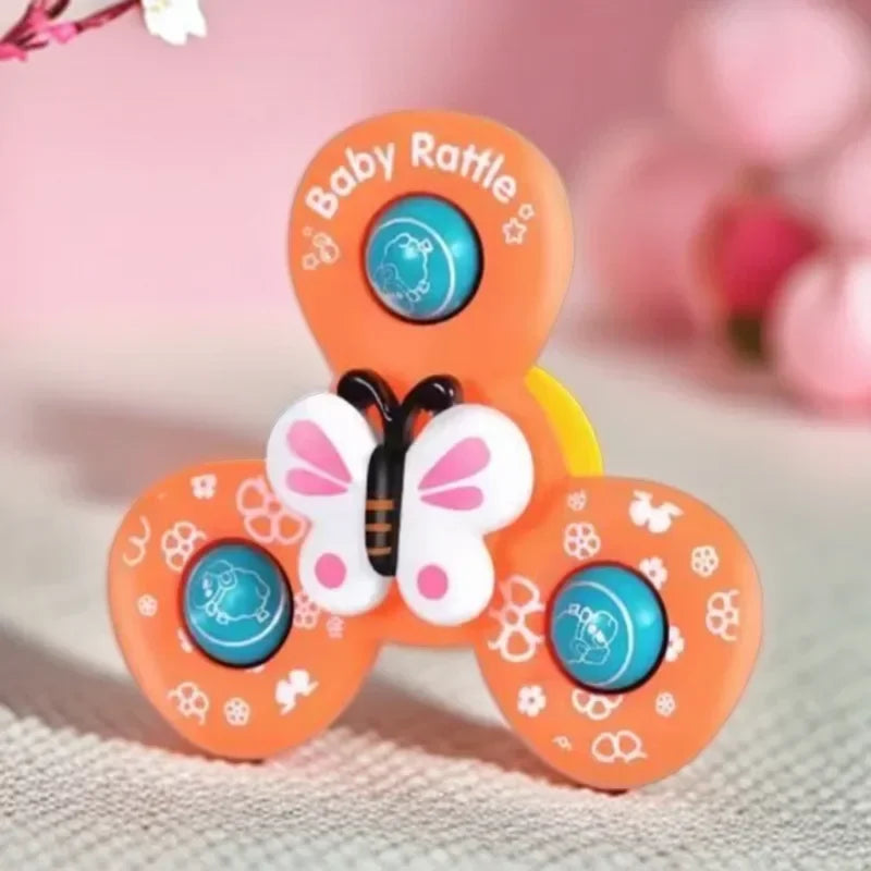 Close-up of the orange butterfly spinner with pink-and-white wings and blue circular inserts