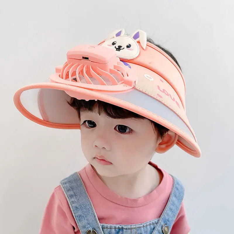 Child wearing an orange fan hat with a cat decoration and wide brim
