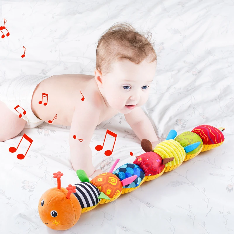 Baby exploring an orange caterpillar rattle with musical note graphics around it