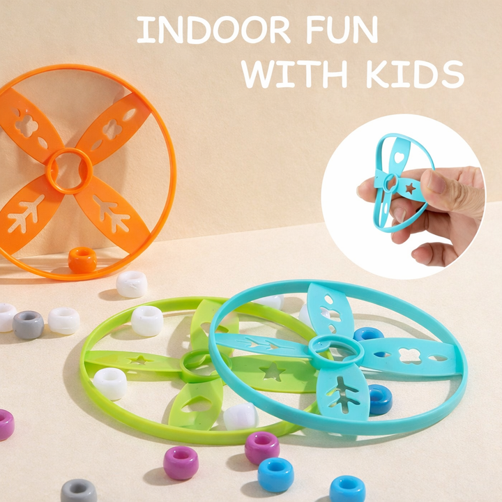 Orange, green, and blue flying discs, with a hand holding one blue disc
