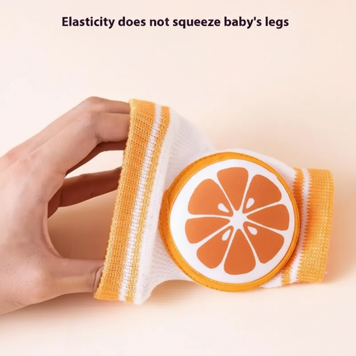 Hand stretching an orange-slice knee pad to show its elastic knit sleeve.