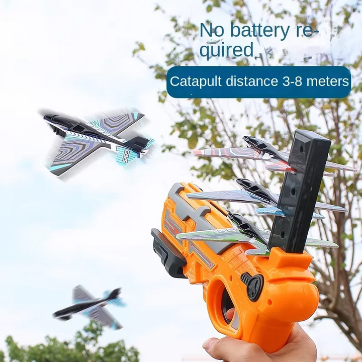 Orange airplane launcher held outdoors with foam planes in flight nearby