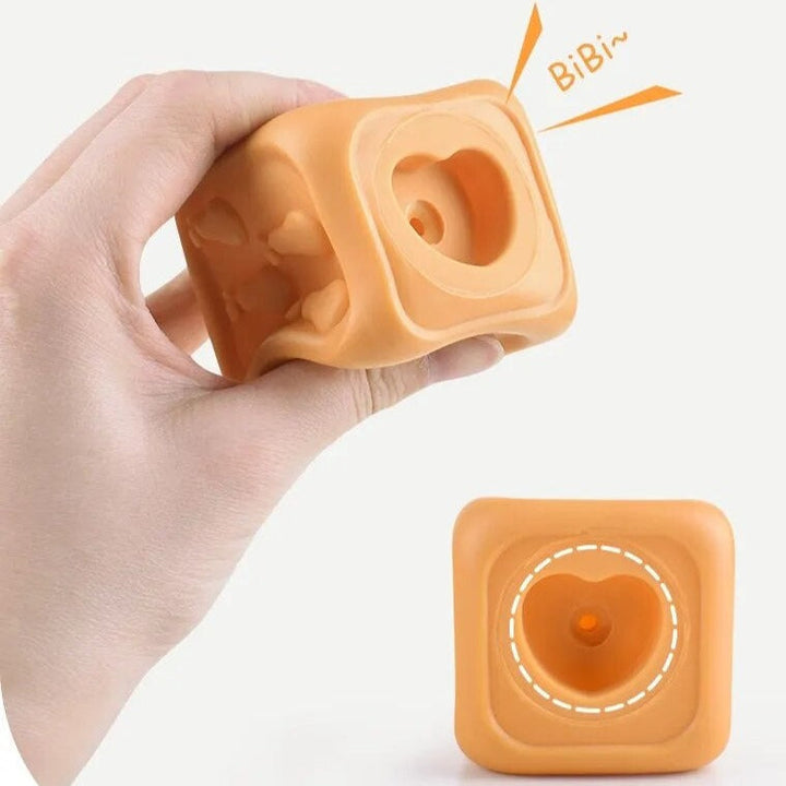 Hand holding an orange textured cube with a close-up of its circular opening