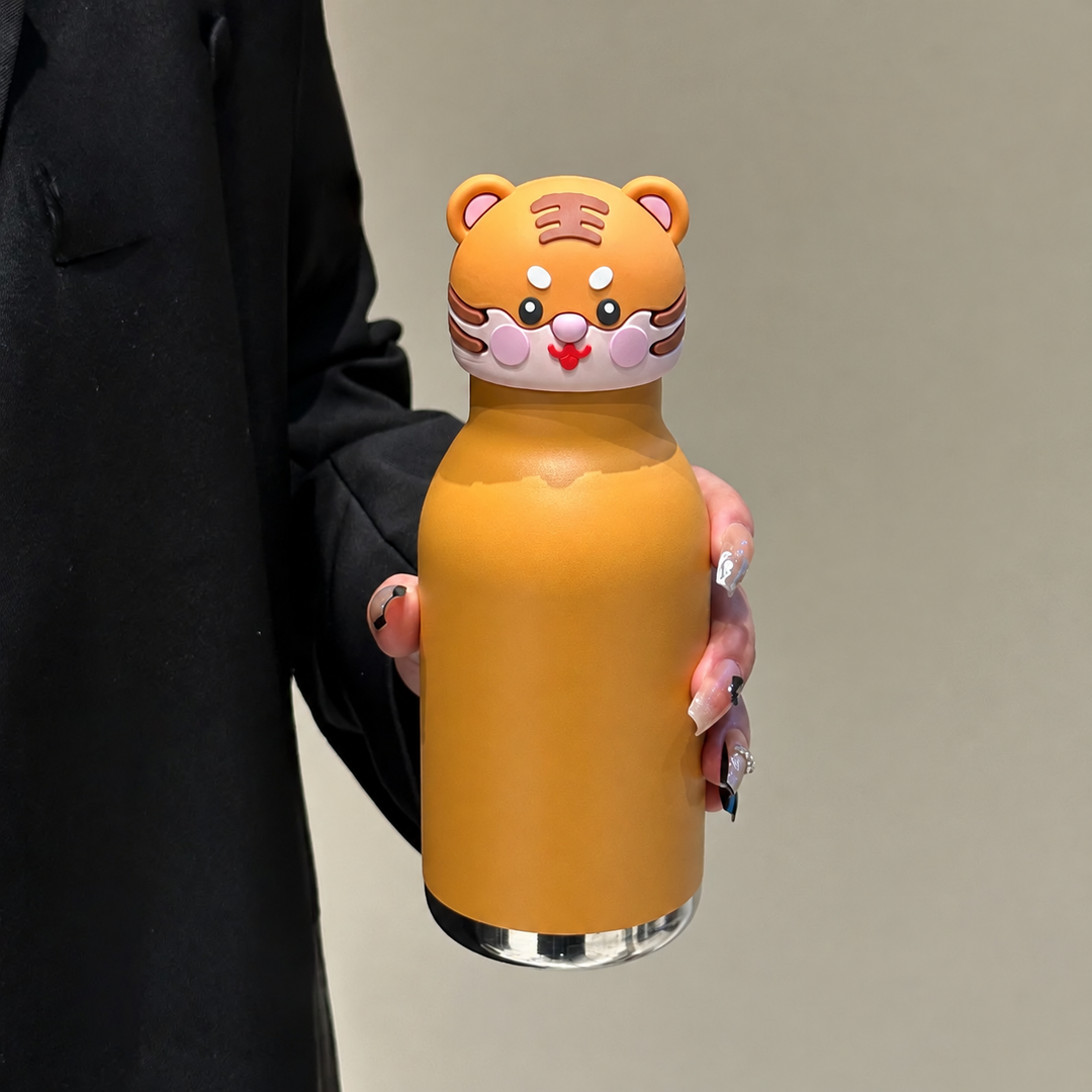 Orange tiger thermos bottle with a tiger-face cap, held in one hand