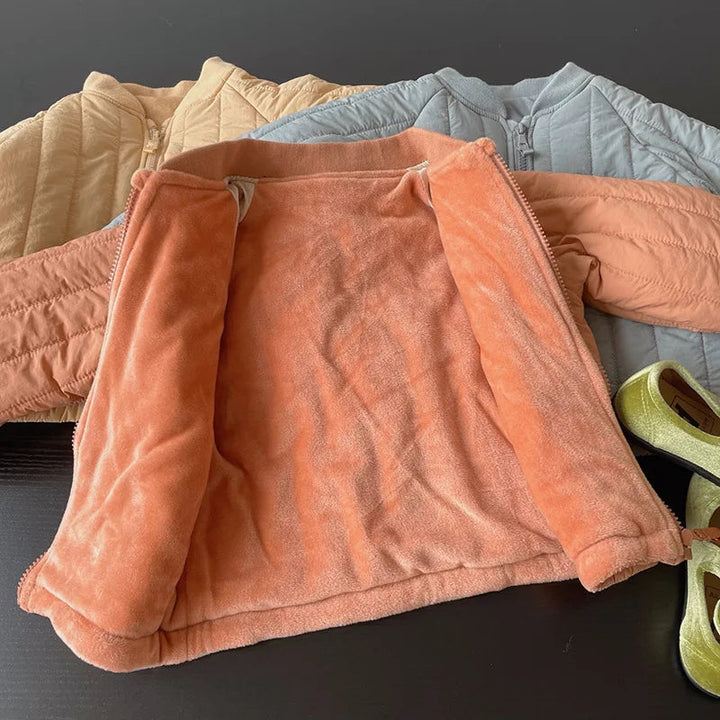 Orange winter coat opened to show its plush lining, with other quilted coats behind it