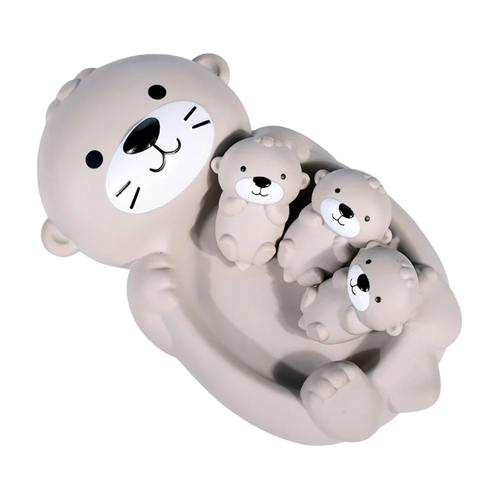 Four-piece otter bath toy family with three small otters resting on the large otter's belly