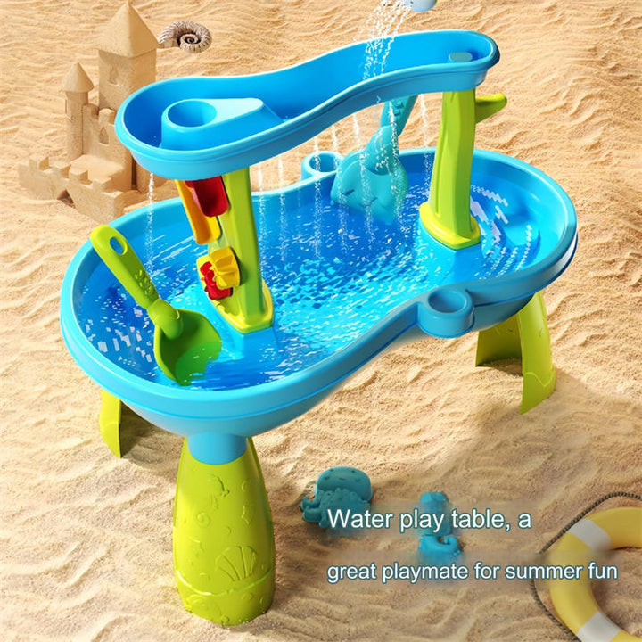Blue and green water table on sand with water flowing into the lower basin