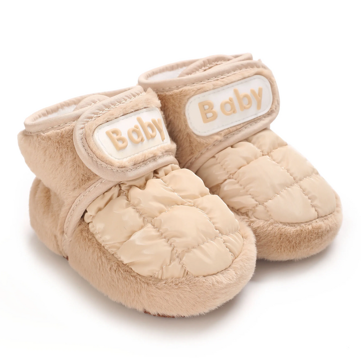 Padded beige baby shoes with quilted uppers, fuzzy trim and wide ankle straps