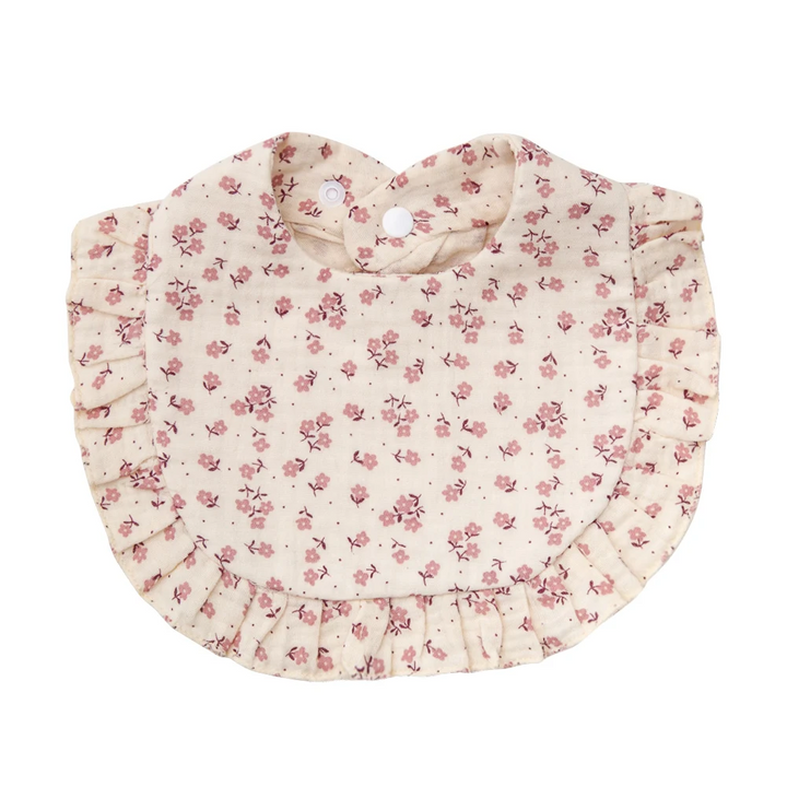Pale pink cotton baby bib with small pink floral clusters and ruffled edging