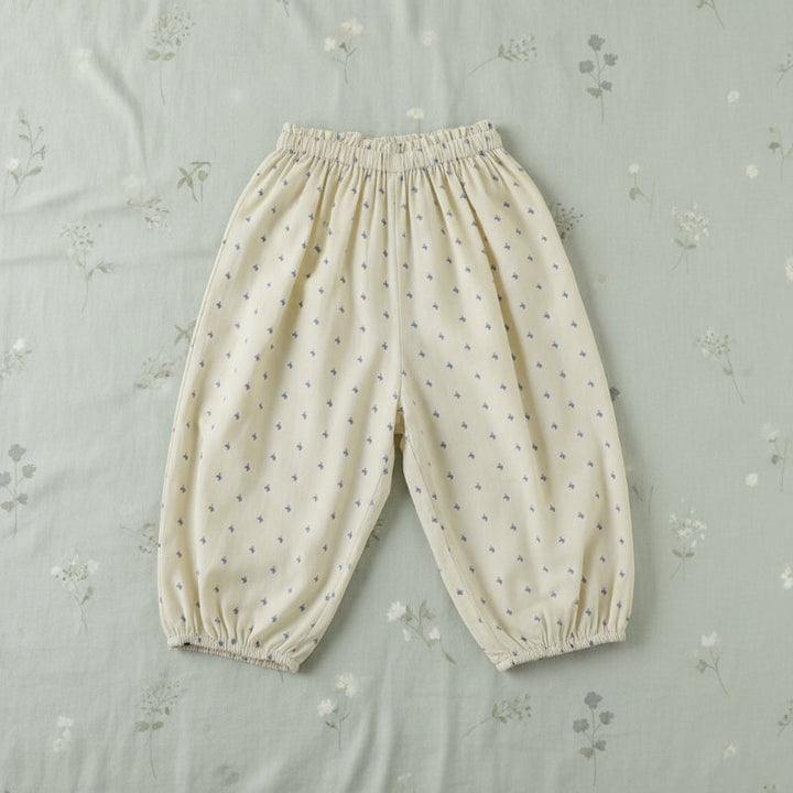 Pale yellow harem pants with small blue motifs, an elastic waist, and gathered cuffs.