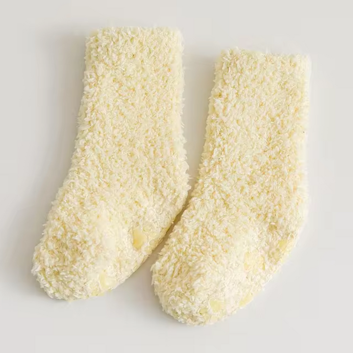 Pair of pale yellow fleece socks laid flat.