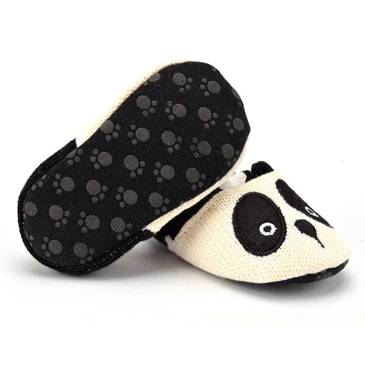 Panda baby slippers with one sole turned up to show paw-print grip details