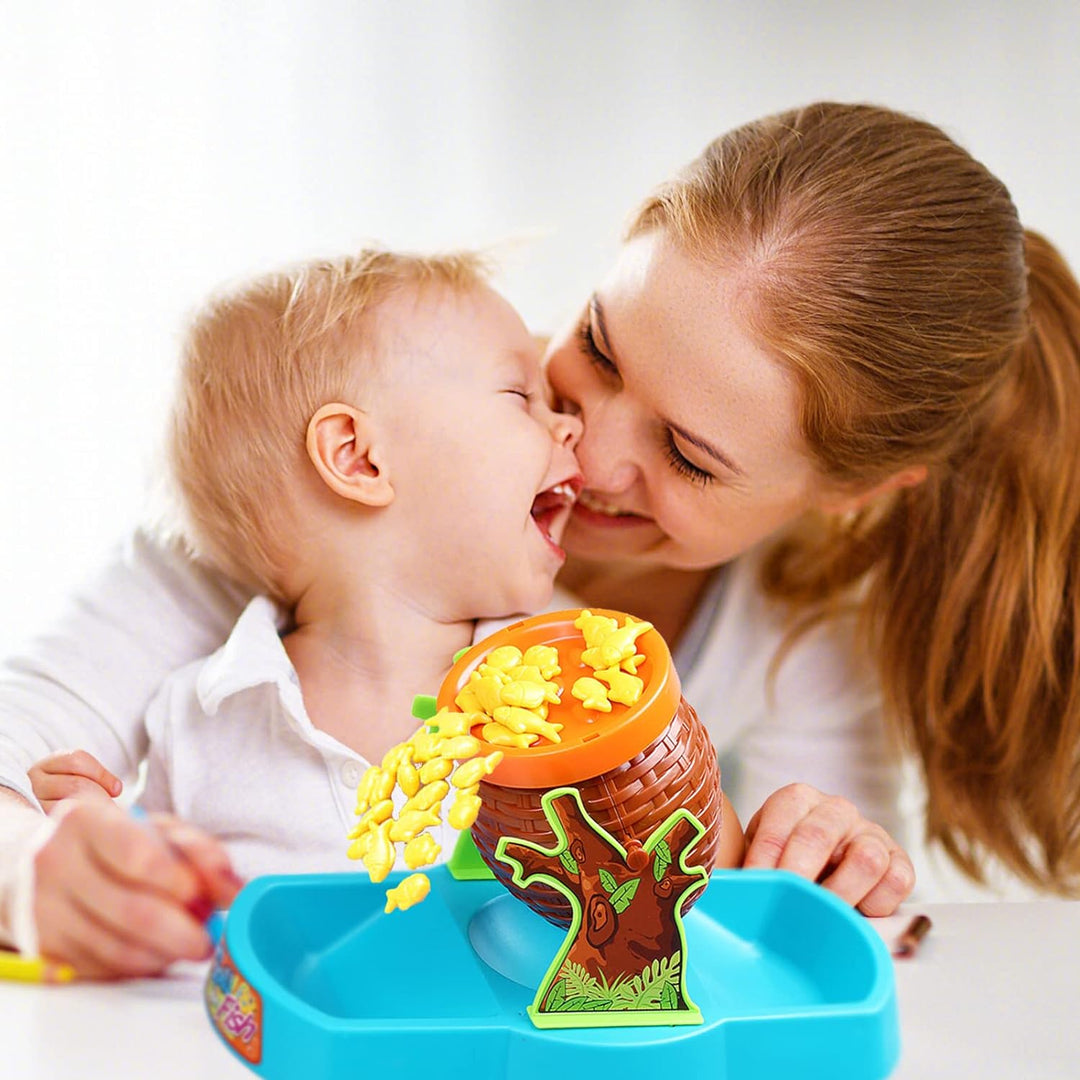A parent and child beside the balancing barrel as yellow fish spill into the tray