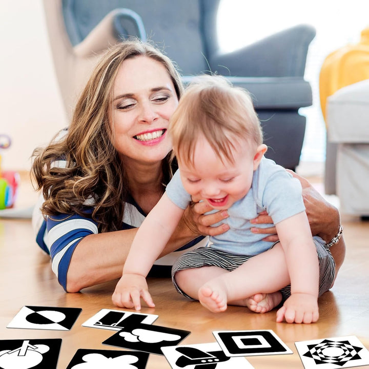 Parent and baby exploring black-and-white picture cards together