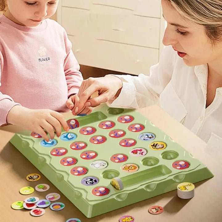 A woman and child playing with round animal tokens on the green memory game board.