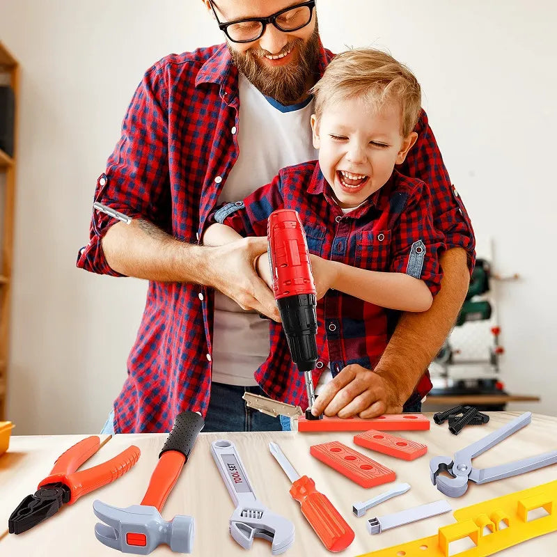 Adult and child using a red toy drill at a table with pretend tools and building pieces