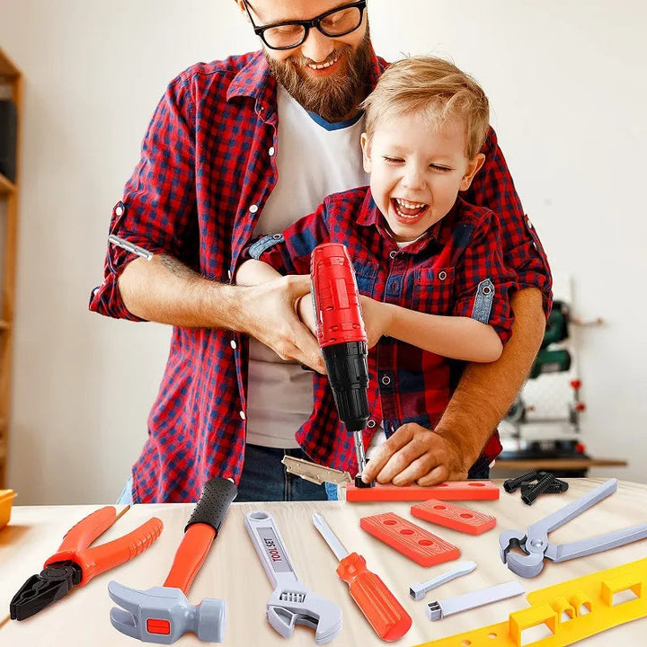 Adult and child using a red toy drill at a table with pretend tools and building pieces