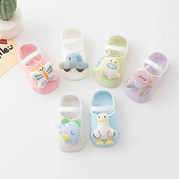 Pastel baby socks with raised character details and slim straps across the tops