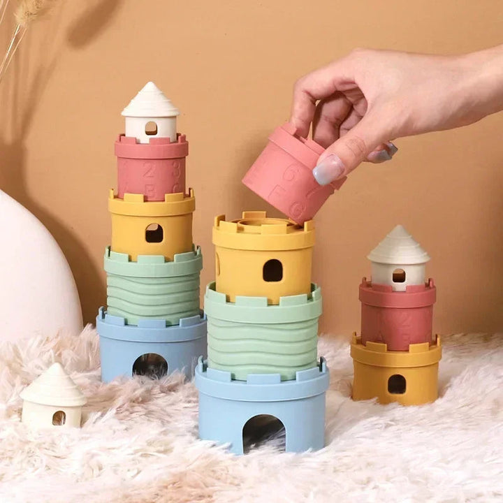 Hand placing a pink cup on one of several pastel castle towers
