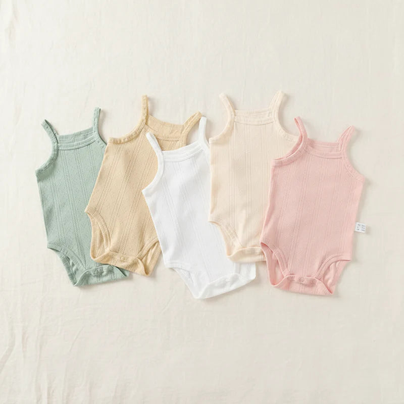 Five pastel baby bodysuits laid flat, showing thin straps and bottom snap closures