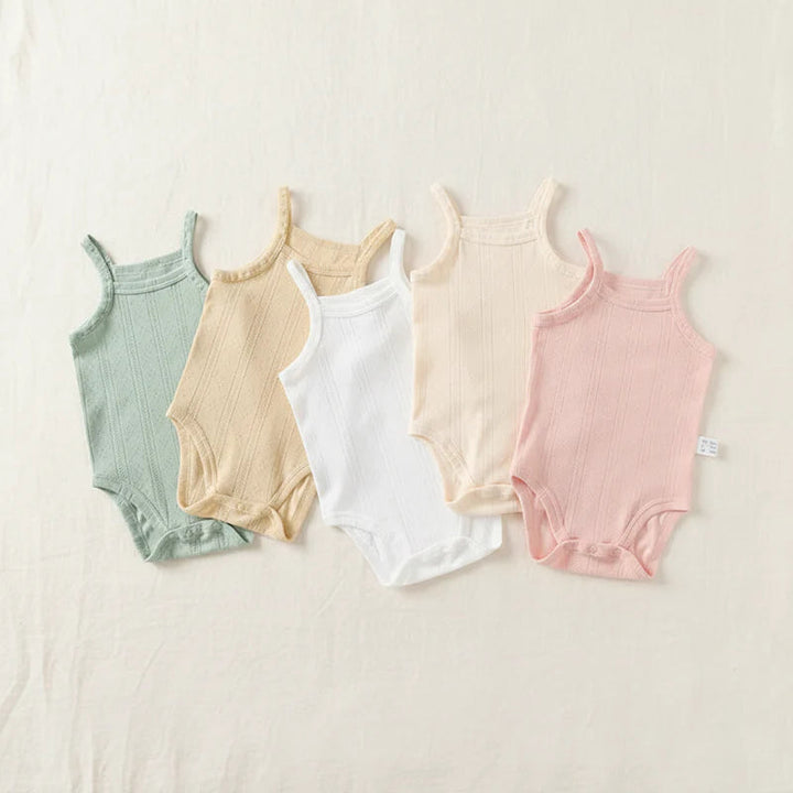 Five pastel baby bodysuits laid flat, showing thin straps and bottom snap closures