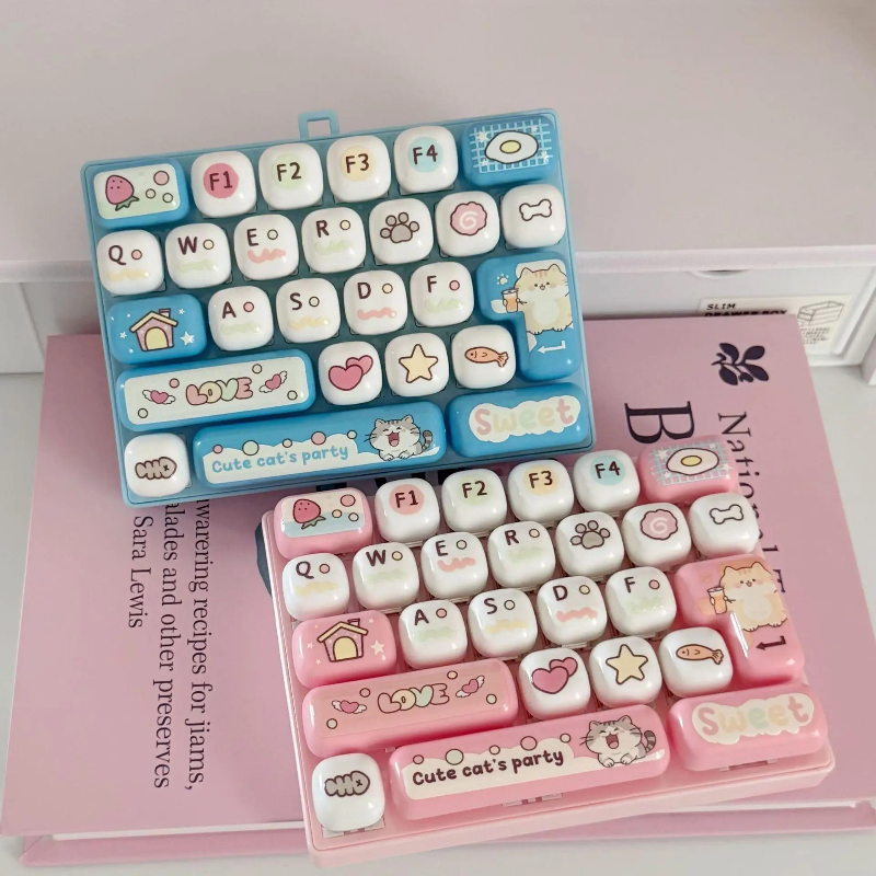 Light blue and light pink fidget keyboards arranged on books