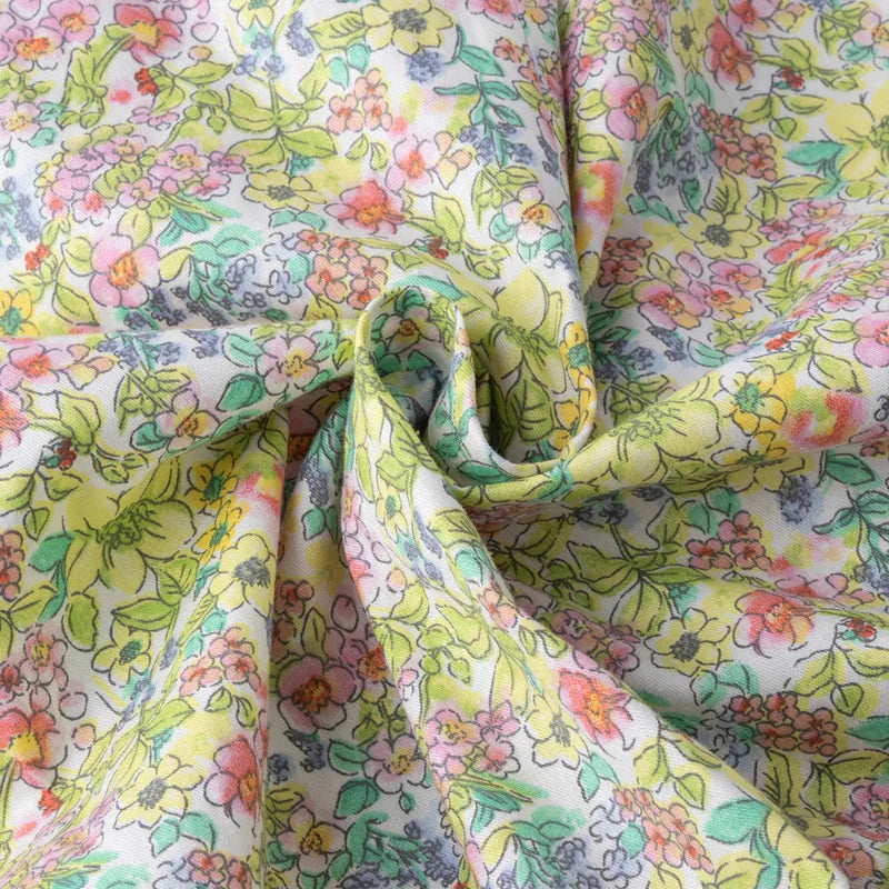 Close-up of gathered floral fabric with pink and yellow flowers and green leaves.