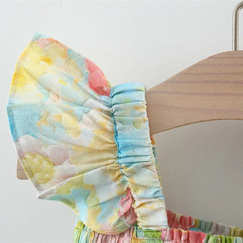 Close-up of a pastel floral flutter sleeve and gathered shoulder strap