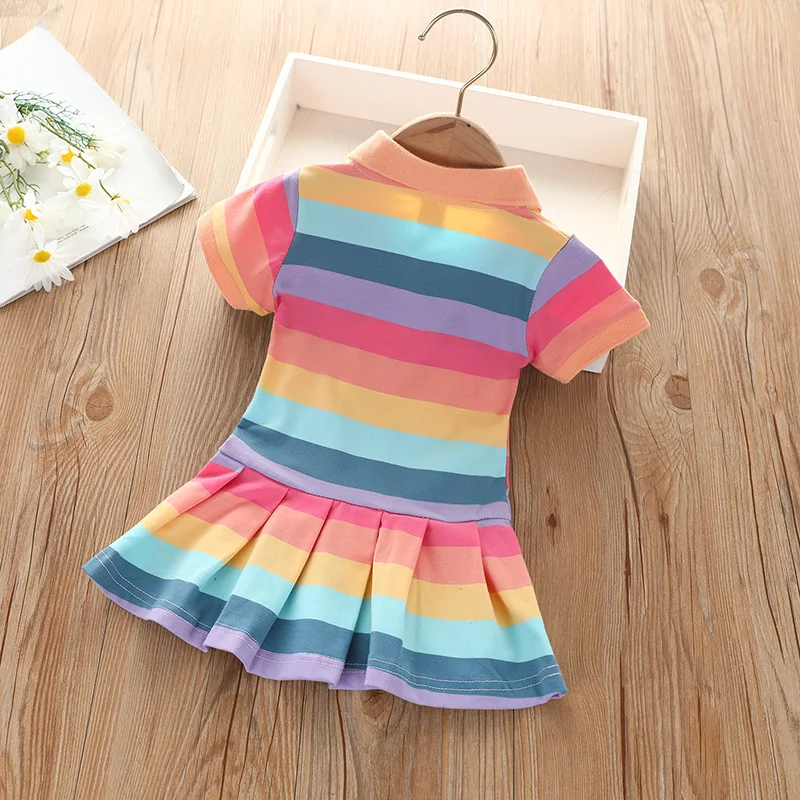 Back of a pastel rainbow-striped polo dress with a low-waisted pleated skirt