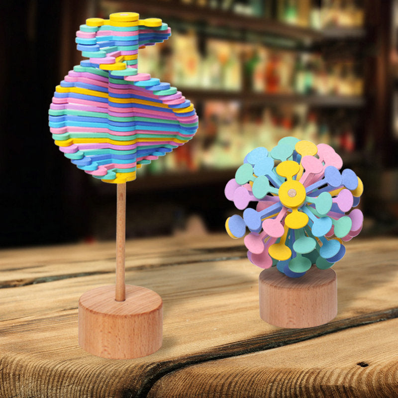 Two pastel wooden rotating lollipop toys standing on a wooden table