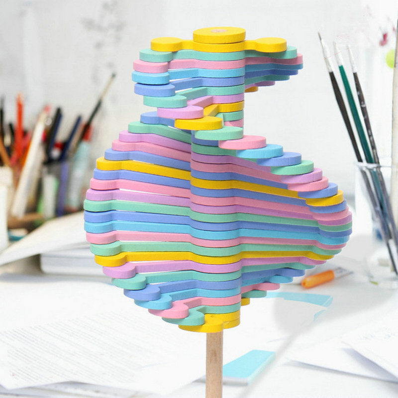 Close-up of pastel wooden layers arranged in a twisting shape on a rotating lollipop toy