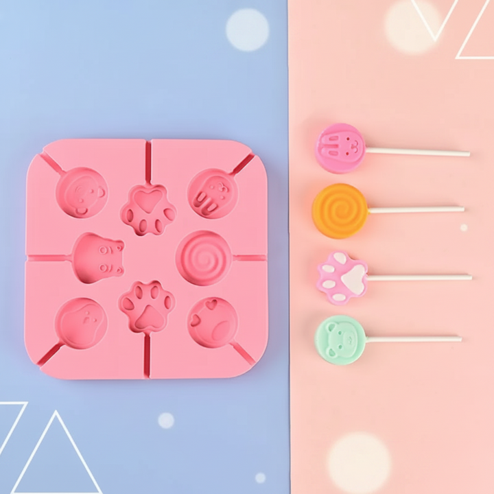 Pink paw and animal lollipop mold beside four colorful sample treats