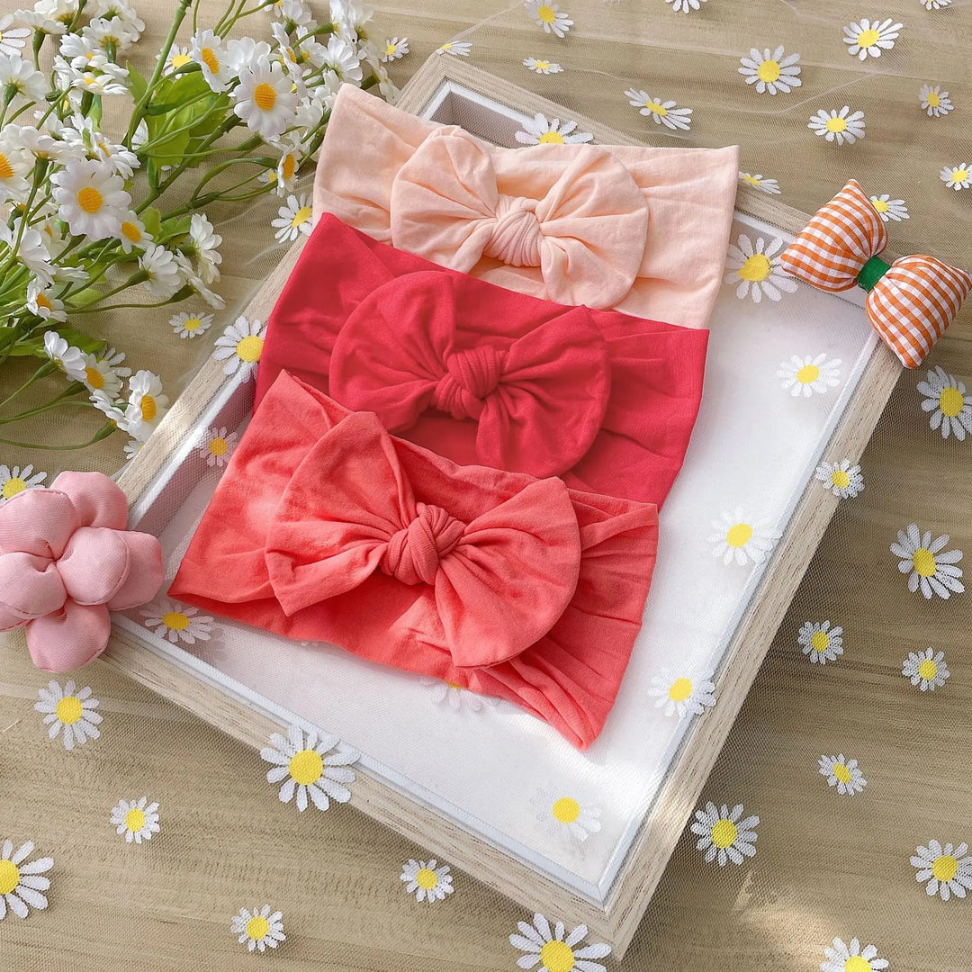 Peach, red, and coral bow headbands with wide fabric bands