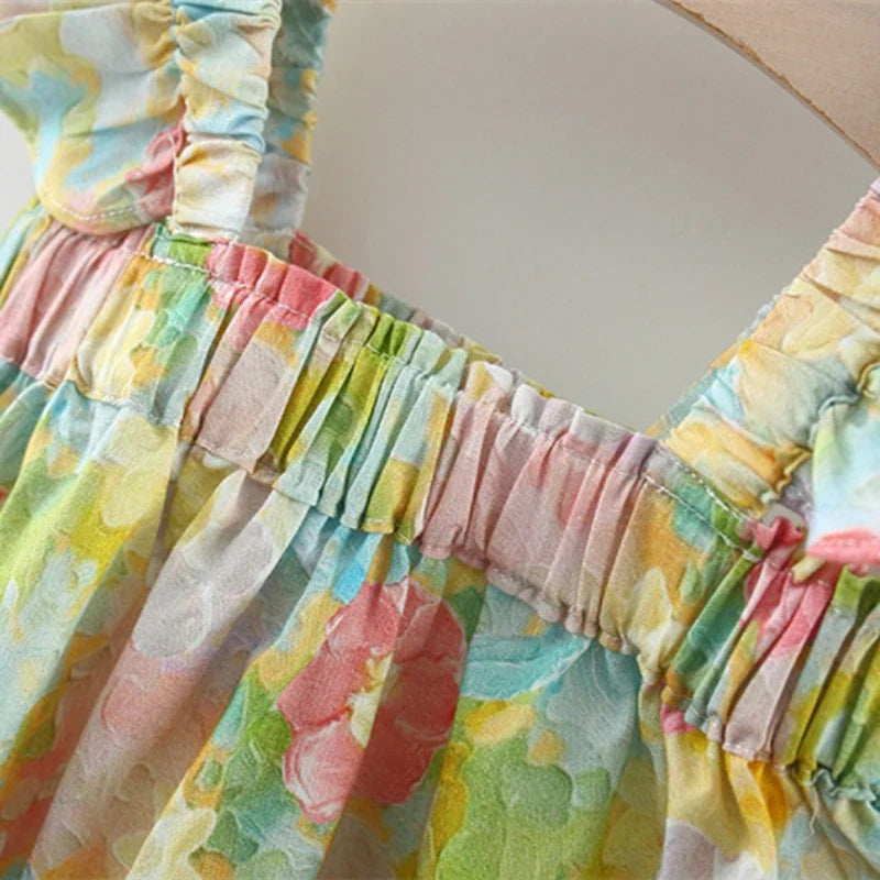 Gathered neckline and shoulder straps on the peony-print baby top