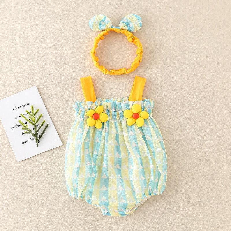 Green baby romper with yellow straps and flower accents, shown beside a matching bow headband