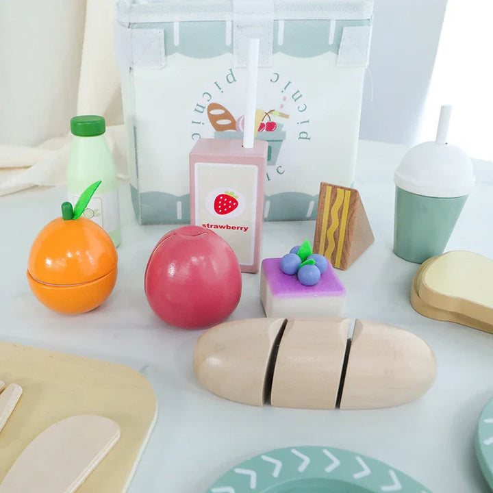 Picnic play food with wooden fruit, bread, pretend drinks, and a striped carry bag