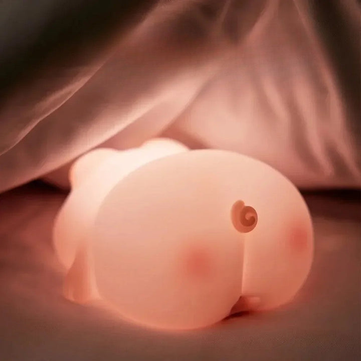 Rear view of a glowing pig night light with a curled tail