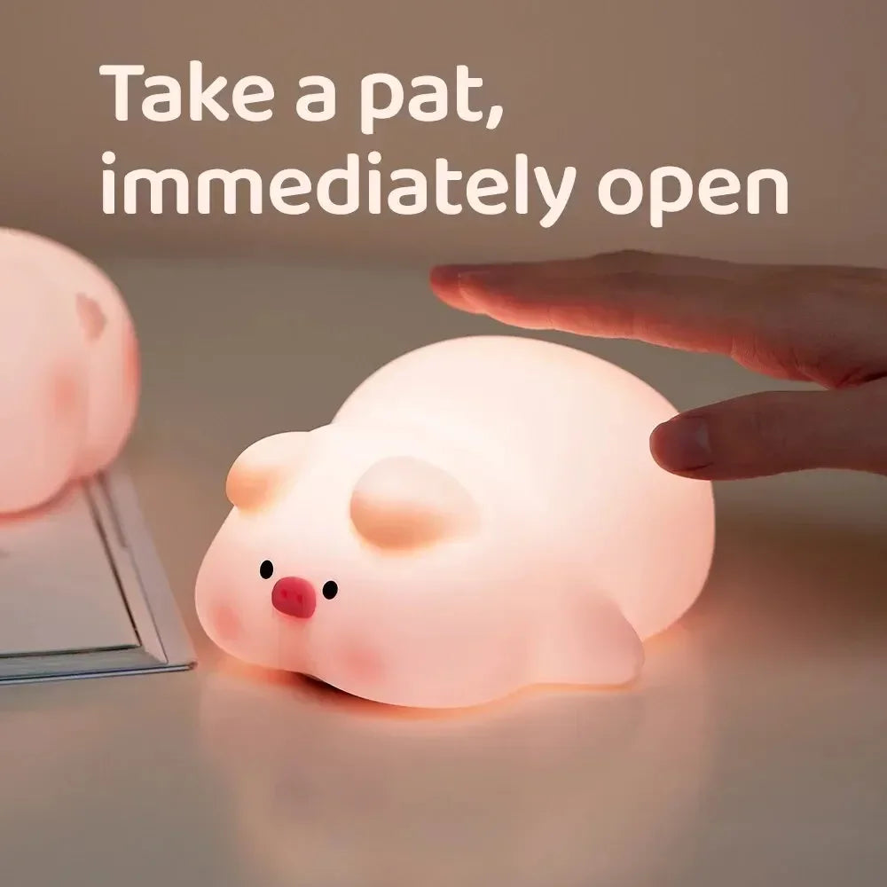 Hand tapping a glowing pig-shaped silicone night light