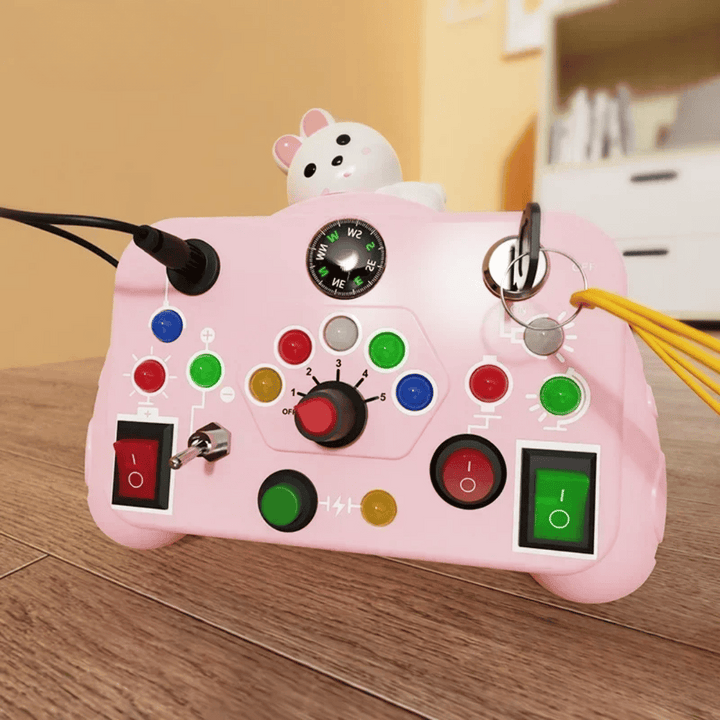 Pink activity board with an animal topper, rotary dial, key, buttons, and switches