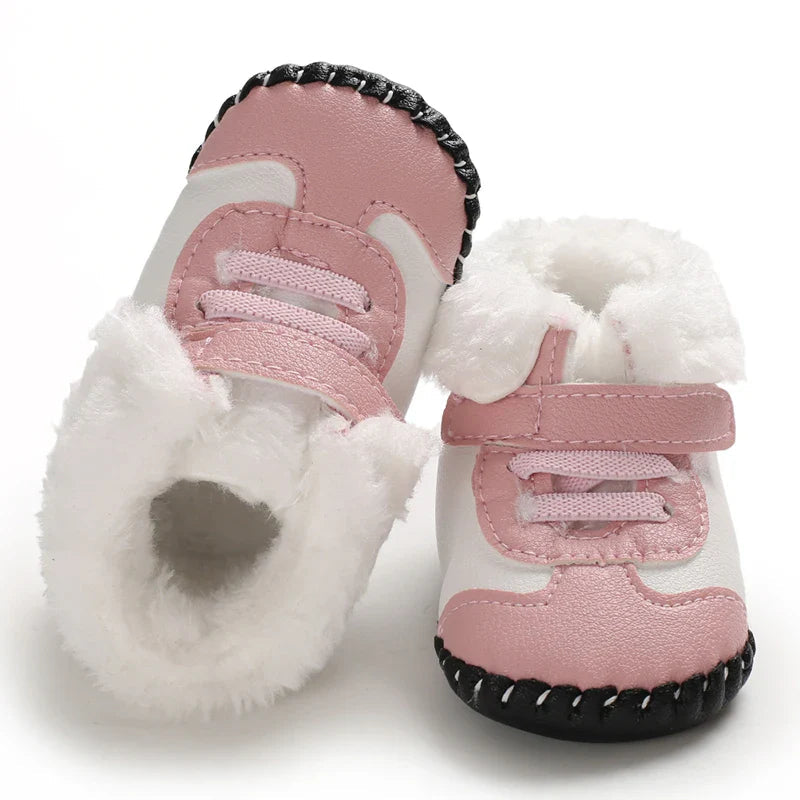 Pink baby boots showing the fluffy lining, front laces, and adjustable strap