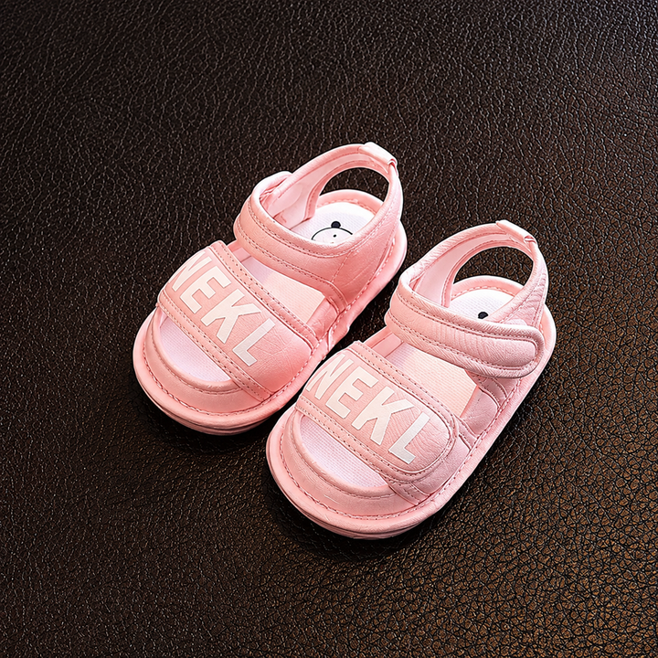 Pair of pink baby sandals with wide front straps and adjustable ankle straps