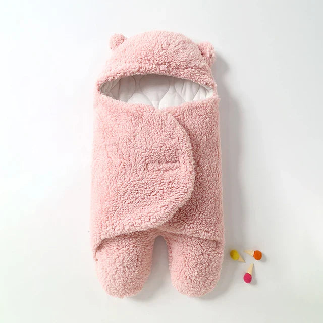 Pink sherpa baby wrap blanket with overlapping front wings and enclosed foot sections.