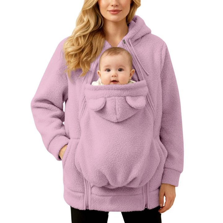 Woman modeling a pink babywearing hoodie with a baby in the front section