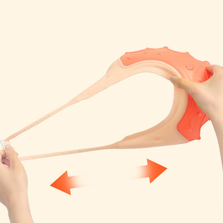 Hands stretching the flexible band of a pink crown-shaped bath cap
