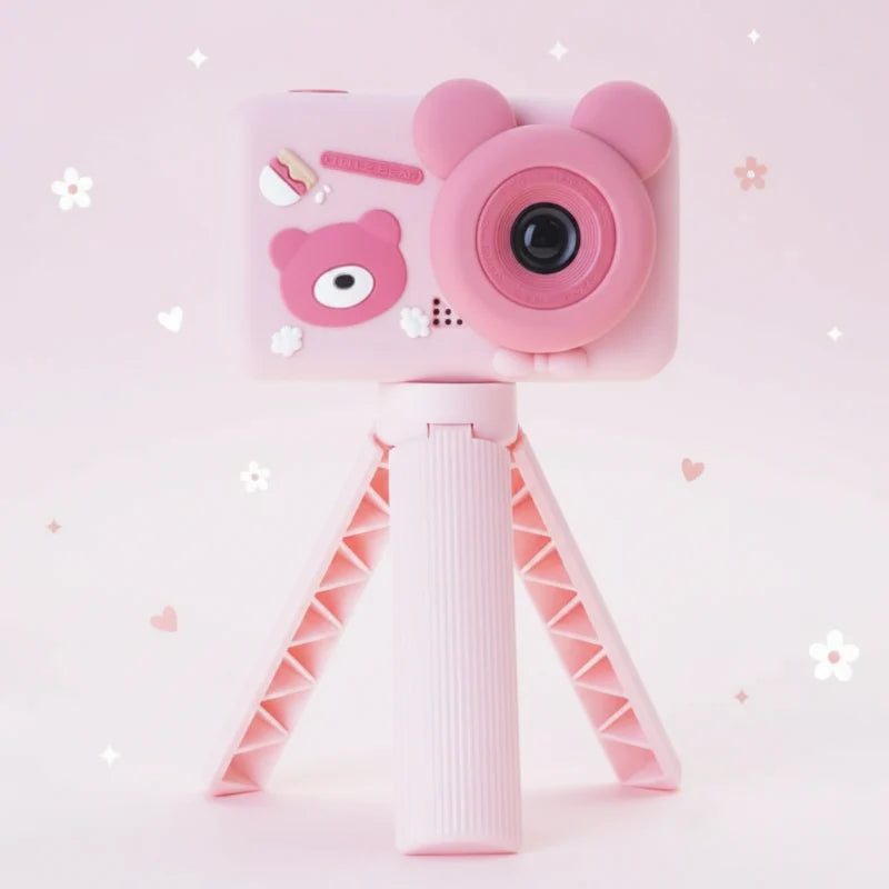Pink bear-shaped kids' digital camera mounted on a three-legged stand