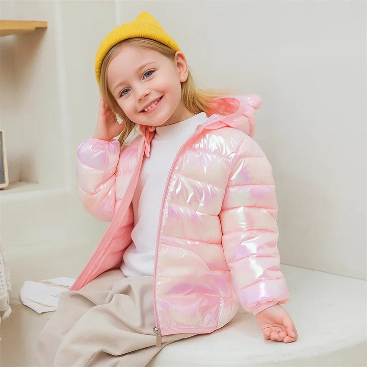 Child wearing a pink iridescent puffer jacket with a bear-ear hood