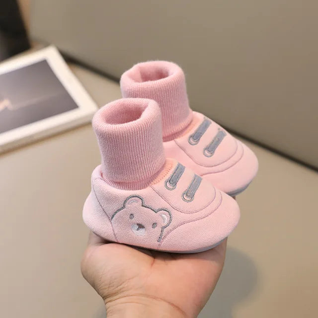 Pink baby sock shoes with ribbed cuffs and decorative lace stitching